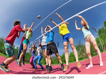 View From Below Of Teens Playing Volleyball