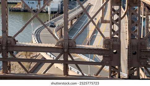 A view between the steel beams of a car driving on one of the merging lanes to the Brooklyn Bridge in Manhattan. FDR Drive from the Brooklyn Bridge pedestrian zone looking south. NYC, USA. - Powered by Shutterstock