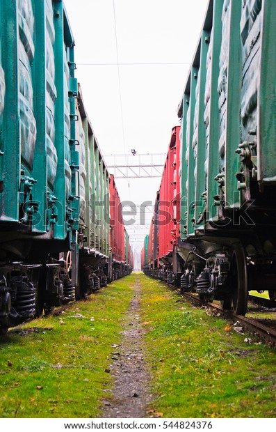 View between two\
cargo trains on cloudy day