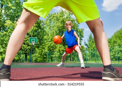 View between two legs of player and boy with ball