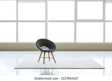 View of big empty room with windows, chair and carpet