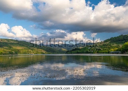 View of blue cloudy sky and wooded mountains reflected in water on a summer sunny day. Samsun, Turkey