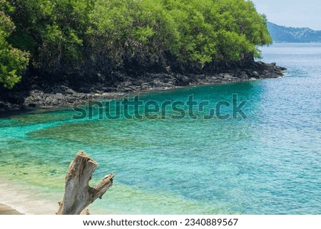 View of Blue Lagoon Beach in Padang Bai, Karangasem Regency, Bali, Indonesia with white sand beach and turquoise waters over coral reefs.