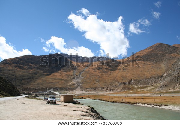 view\
of blue sky and brown mountain with river in\
tibet