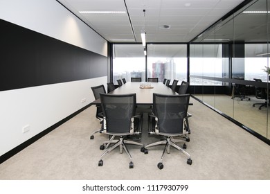 View of a board room within a larger office with a view of the cityscape from the near by window with plenty of natural light modern office fitout