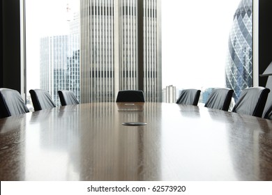 view of boardroom table with chairs and city buildings in background