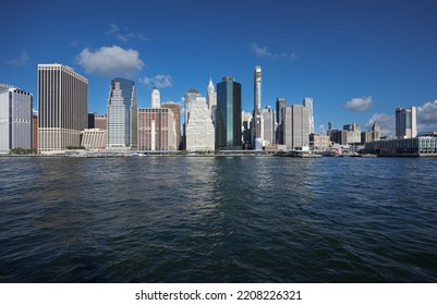 View From A Boat To East River With Manhattan And Brooklyn Bridges Landmark And Other Iconic Buildings From New York City During A Beautiful Sunny Day.