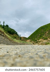 View from the bottom of the road and sky between greenery hills