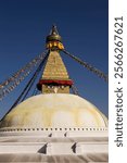 View of Boudha Stupa with prayer flags is a tibetan buddhism spiritual landmark seen as the embodiment of the enlightened mind of all the Buddhas located in Boudhanath, city of Kathmandu, Nepal