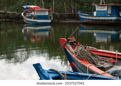 view, bow of fishing boat, anchor, ropes, fishing net, in the background, fishing boats, anchored, pedestrian crossing, wooden, rustic, elevated, river channel, low and calm, ebb tide - Powered by Shutterstock