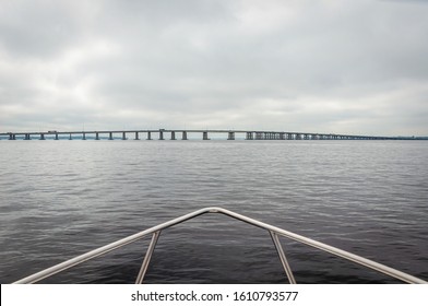 View of the bow of a fishing boat heading towards a Jacksonville bridge, on a rainy and overcast morning, Florida, USA.