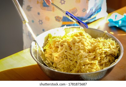 View Of Bowl With Shredded Potatoes Being Mixed With Other Ingredients; Making Potato Pancakes Latkes For Jewish Holiday Hanukkah