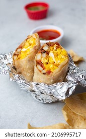 A View Of A Breakfast Burrito In An Unwrapped Foil Base.