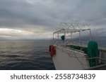 View of the bridge wings of a ship at sea with razor wire on top of the lookout post to keep seagull away from sitting