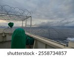 View of the bridge wings of a ship at sea with razor wire on top of the lookout post to keep seagull away from sitting