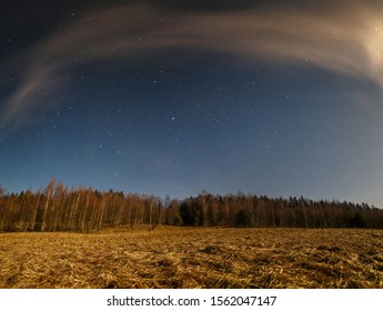 View Of The Bright Autumn Night Sky Over A Brown Autumn Field And Forest