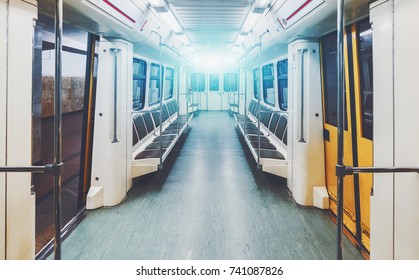 View Of Bright Empty Interior Of Modern Subway Train Car While It Is Waiting On Station With Yellow Doors Opened; Contemporary Underground Railway Carriage Indoors With No One Inside, Empty Seats