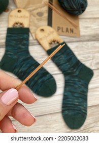 View Of Broken Knitting Needle With Hand Knitted Socks In The Background