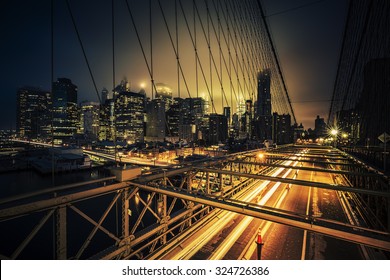 View Of Brooklyn Bridge At Night With Car Traffic