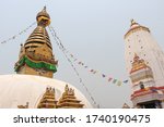 View of buddhist Swayambhunath stupa, also known among tourists as Monkey Temple, with traditional "Eyes of Buddha" painting and Basundhara Devi Temple. Theme of travel in Kathmandu, Nepal.