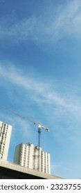 View of a building under construction, with a tower crane, in the morning under a clear sky