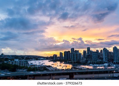 view of the buildings of vancouver city skyline and a marina during a beautiful sunset