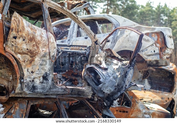 A view of burnt-out cars after rocket attacks by\
the Russian military. War of Russia against Ukraine. Civil vehicle\
after the fire. Cemetery of cars in the city of Irpin. Rusty pile\
of metal