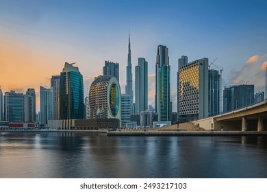 View of the business and financial center of Dubai in the United Arab Emirates. Skyscrapers in the evening at sunset. Sunlight reflection on the glass surfaces of the skyscrapers with some clouds - Powered by Shutterstock