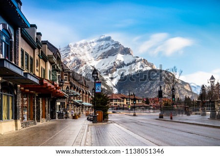 View of a busy street at Banff city Canada during transition season from winter to snow