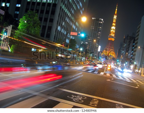 View of busy street at night with Tokyo Tower in\
the distance.  Tokyo,\
Japan.