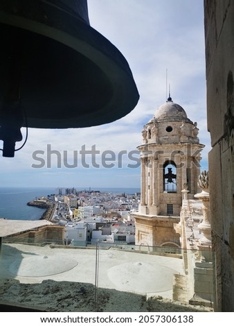 On the left, part of Gaeta Cathedral (Italy) On the right, an old building and the silhouette of an umbrella line. In between the view of the old town and the port of Gaeta.