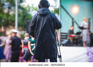 View of a camera man operator working during tv reportage, online broadcasting of concert, professional videographer with camera filming live event