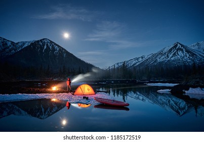 View of camp life in a mountain terrain. Lake shore with canoe