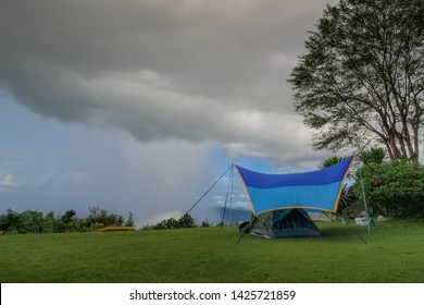 View Of Camping Tent On Green Grass With Rain Storm And Cloudy Sky Background, Pha Chu Camp Site, Sri Nan National Park, Nan, Thailand.