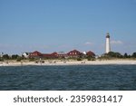 View of Cape May lighthouse and vintage red buildings from the water