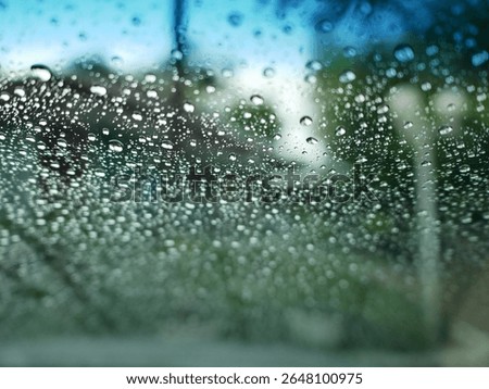 view from car inside, focus at the rain drops on the windshield while the wipers is working