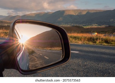 View From A Car On A Mountains And Reflection In A Car Mirror Of A Sun Rise Over Mountain Peak. Connemara, County Galway, Ireland. Car Travel With Stunning Nature Scenery. Teal And Orange Colors.