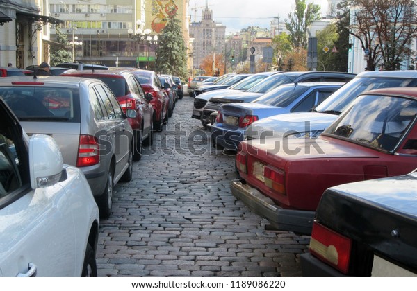 View of a car\
parking in a full parking\
lot.