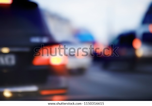 view of car in  traffic jam / rear view of the
landscape from window in car, road with cars, lights and the legs
of the cars  night view