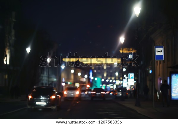 view of car in  traffic jam / rear view of the\
landscape from window in car, road with cars, lights and the legs\
of the cars  night view