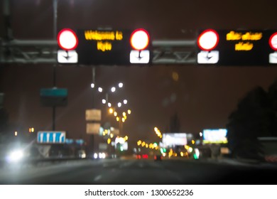 View from the car window when driving. Defocused lights of the night city, avenue and street lamps.