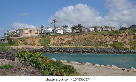 View of the Carlsbad lagoon and homes perched on the cliff on a sunny day                              