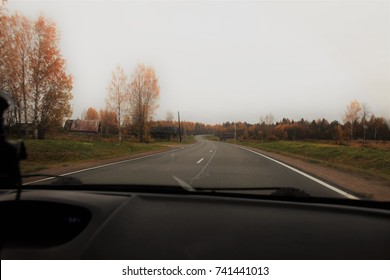 View from the car's cab on the paved road in late autumn