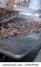 A View Of A Carving Knife Cutting Trimmings Off Of Beef Shawarma Cooked On A Rotisserie Spit.