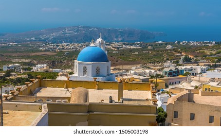 A View From The Castle In Pyrgos, Santorini Towards A Blue Dome Church In Summertime