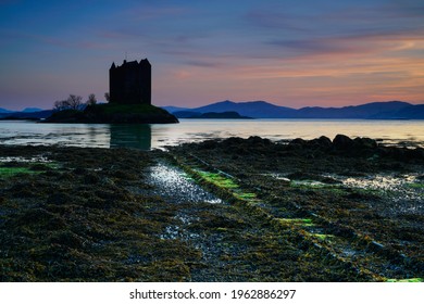 View Of Castle Stalker Silhouette At Sunset. Located In The Highlands Of Scotland.