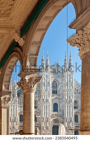 View of the Cathedral of Milan, or Duomo, as seen through one of the arches of Gallery Vittorio Emanuele II. Duomo is the most popular landmark of Milan, Italy, Europe.