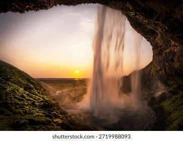 The view from the cave held two kinds of falling: the sun, spilling its light, and the waterfall, pouring its soul over the rocks.