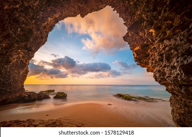 View from the cave a sandy beach along the ocean at golden sunset. Bali, Indonesia. - Powered by Shutterstock
