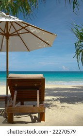 View Of Chase Lounge And White Umbrella On The Beach.